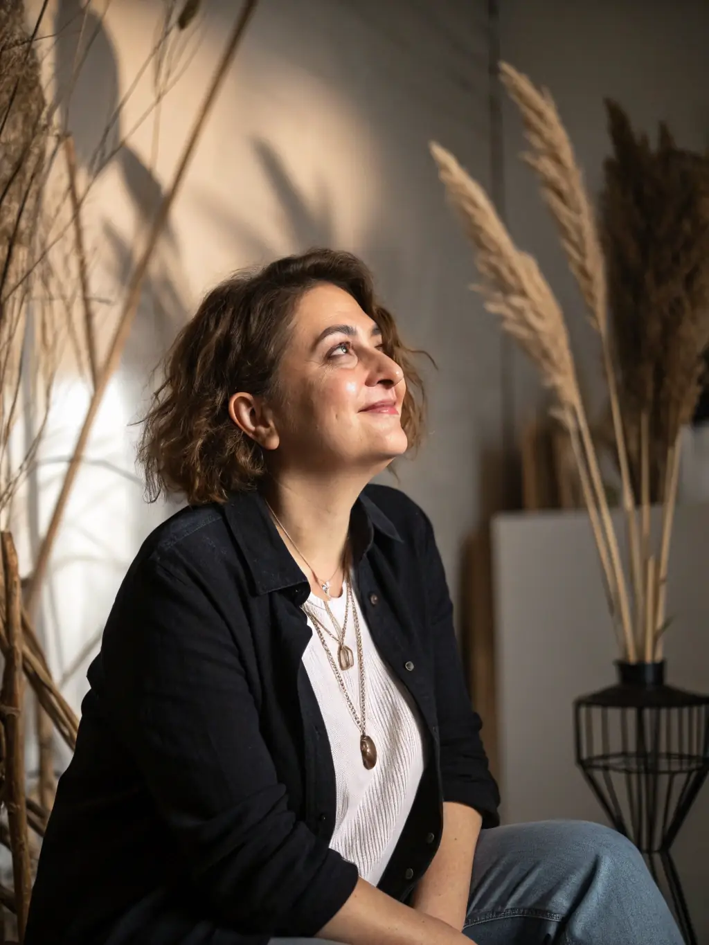 A professional photographer taking a portrait of a young woman in a studio setting, using soft, diffused lighting to highlight her features.